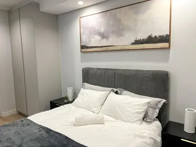 a bedroom with a bed with a painting above it at 4208 on Ellipse, Waterfall, Midrand in Midrand