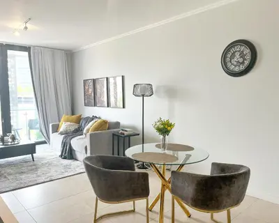 a living room with a table and chairs and a couch at 4208 on Ellipse, Waterfall, Midrand in Midrand