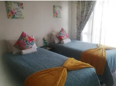two beds sitting in a room with a window at IRIS at THE BLYDE in Pretoria