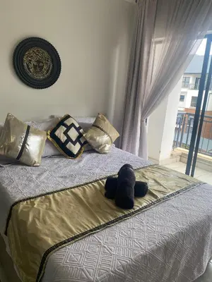 a bed with a stuffed animal laying on it at IRIS at THE BLYDE in Pretoria