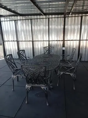 a table and chairs in a screened in area with a table and chairs at DHALI COUNTRY house in Ermelo
