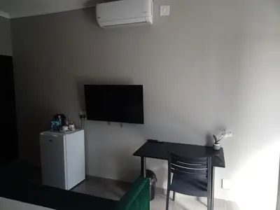 a living room with a table and a flat screen tv at DHALI COUNTRY house in Ermelo