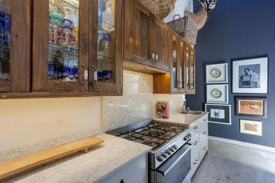 a kitchen with wooden cabinets and a stove top oven at Bushveld Villa w Pool, Firepit & Outdoor Living in Hoedspruit