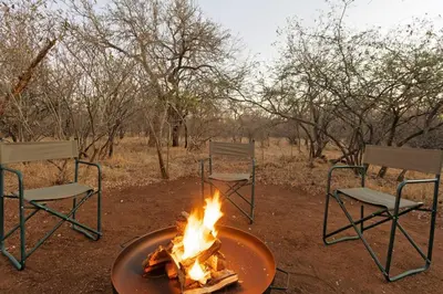 a fire pit with chairs and chairs around it at Bushveld Villa w Pool, Firepit & Outdoor Living in Hoedspruit