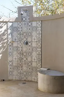 a bathroom with a tile wall with a shower at Bushveld Villa w Pool, Firepit & Outdoor Living in Hoedspruit