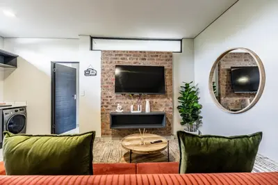 a living room with a couch and a tv at Menlo Park Luxury Free Parking King bed Workstation 3 km to Menlyn Maine in Pretoria