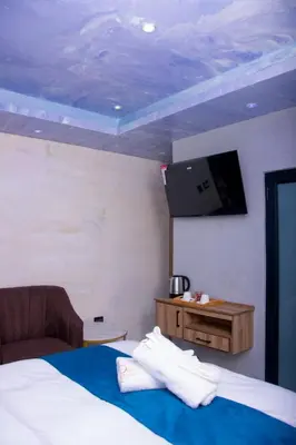 a bedroom with a bed with a tv on the wall at Meriam Base Lodge in Kempton Park