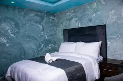 a bedroom with a large bed with a painted wall at Meriam Base Lodge in Kempton Park