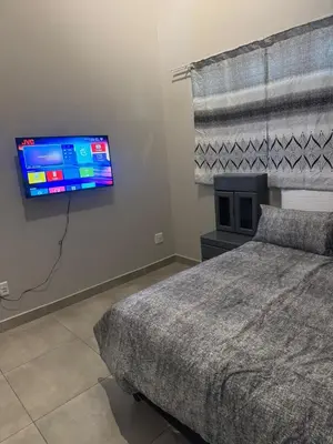a bedroom with a bed and a flat screen tv at Circa apartment unit 42 in Pretoria