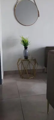 a table with a plant on it with a mirror at Circa apartment unit 42 in Pretoria