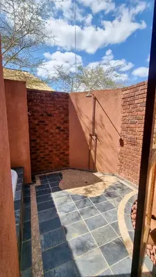 a patio with a brick wall and a stairway at Tholo Bush Stay