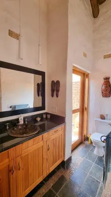 a bathroom with a sink and a toilet and a mirror at Tholo Bush Stay