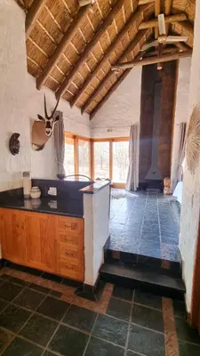 a large room with a kitchen with a counter top at Tholo Bush Stay