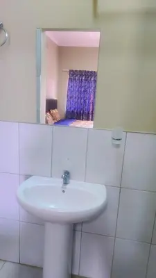 a white sink in a bathroom with a mirror at Binu motel Kempton park in Johannesburg