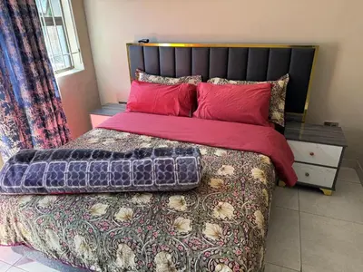 a bedroom with a large bed with red pillows at Binu motel Kempton park in Johannesburg