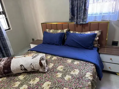 a bedroom with a bed with blue sheets and pillows at Binu motel Kempton park in Johannesburg