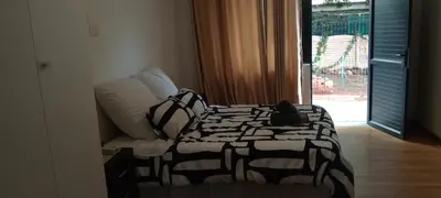 a bed with a black and white comforter in a room at Villa paradiso in Centurion