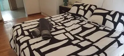 a black and white bed with a pair of shoes on it at Villa paradiso in Centurion