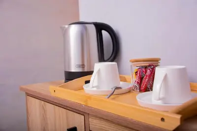 a wooden counter with a coffee maker and cups on it at Meriam Base Lodge in Kempton Park