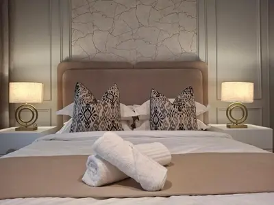 a bedroom with a bed with two lamps and towels at 139 Menlyn Maine in Pretoria