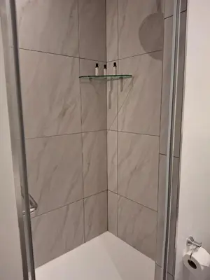 a shower with a glass door with a glass shelf at 139 Menlyn Maine in Pretoria