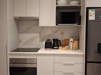 a kitchen with white cabinets and a counter top at 139 Menlyn Maine in Pretoria