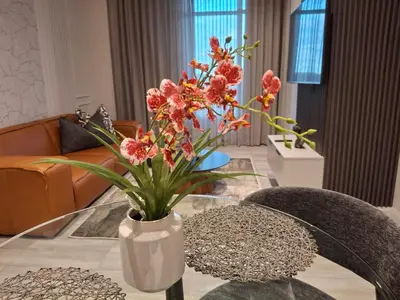 a vase of flowers sitting on a glass table at 139 Menlyn Maine in Pretoria