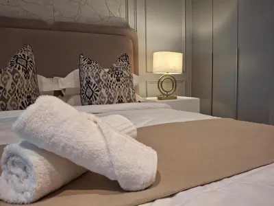 a bedroom with a bed with white towels on it at 139 Menlyn Maine in Pretoria