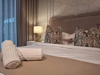 a hotel room with a bed with towels on it at 139 Menlyn Maine in Pretoria