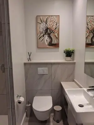 a white bathroom with a toilet and a sink at 139 Menlyn Maine in Pretoria