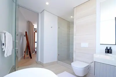 a bathroom with a toilet and a glass shower at 1 Thango Executives Ellipse Gallileo in Midrand