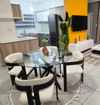 a glass table and chairs in a kitchen at The Blyde Luxury Apartments in Pretoria