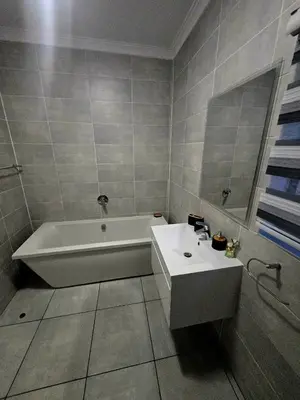 a bathroom with a white tub and a sink at The Blyde Luxury Apartments in Pretoria