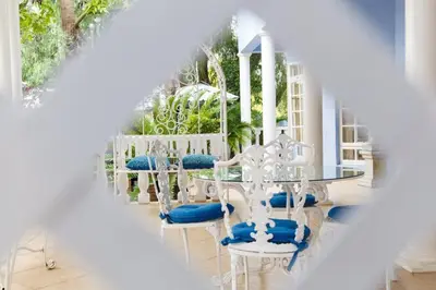 a dining room with white tables and blue chairs at Angels Place Boutique Guesthouse in Pretoria