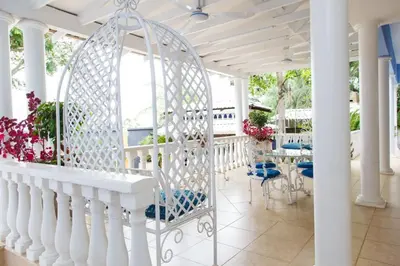 a white porch with blue chairs and a swing at Angels Place Boutique Guesthouse in Pretoria