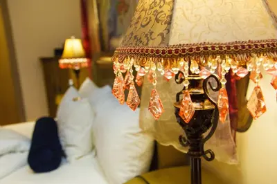 a lamp in a bedroom with a bed and pillows at Angels Place Boutique Guesthouse in Pretoria