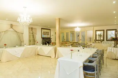 a banquet hall with white tables and chairs and chandeliers at Angels Place Boutique Guesthouse in Pretoria