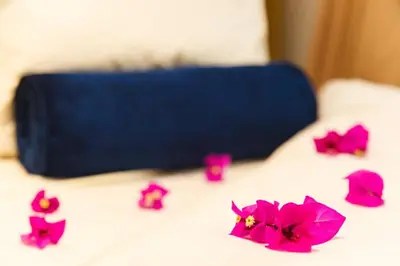 a group of pink flowers on a bed with a blue bag at Angels Place Boutique Guesthouse in Pretoria