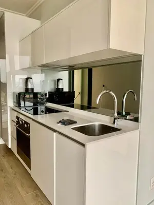 a kitchen with white cabinets and a sink at Awesome Apartment in Ellipse Waterfall Cassini in Midrand