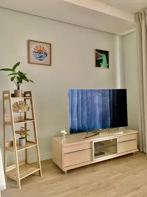 a living room with a flat screen tv on a entertainment center at Awesome Apartment in Ellipse Waterfall Cassini in Midrand