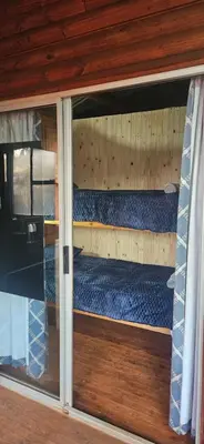 a bunk bed in a room with a window at Bushbaby Cabin in Louwʼs Creek
