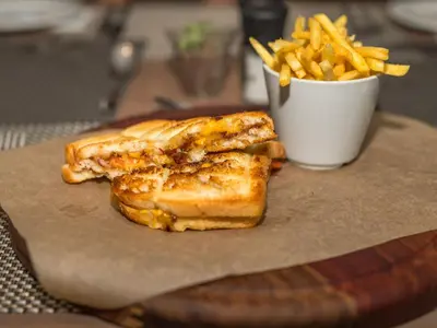 a grilled cheese sandwich and french fries on a table at ANEW Hotel Centurion Pretoria in Centurion