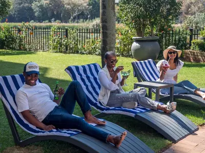 three people sitting in lawn chairs in a yard at ANEW Hotel Centurion Pretoria in Centurion