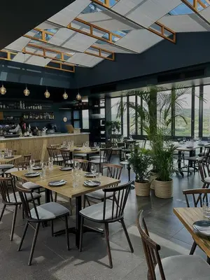 a restaurant with wooden tables and chairs and a bar at TrilogyatMenlyn in Pretoria