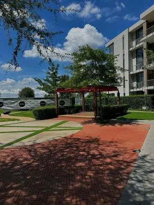 a pavilion in front of a building with a tree at TrilogyatMenlyn in Pretoria