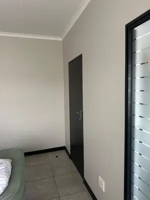 a room with a black door and a bed at Comfortable stay in Midrand in Midrand