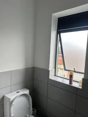 a bathroom with a toilet and a window at Comfortable stay in Midrand in Midrand