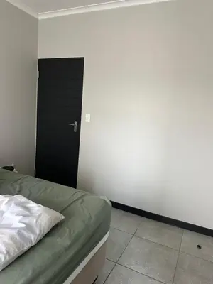 a bedroom with a bed and a black door at Comfortable stay in Midrand in Midrand