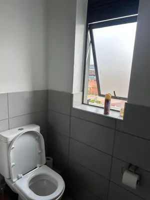 a bathroom with a toilet and a window at Comfortable stay in Midrand in Midrand