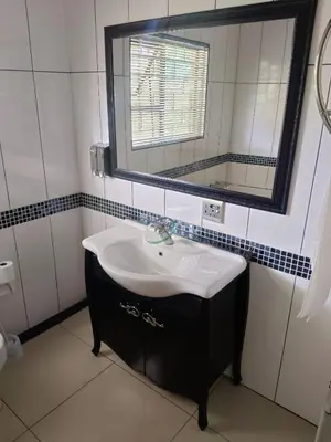 a bathroom with a sink and a mirror at Ikhutseng Guesthouse in Graskop